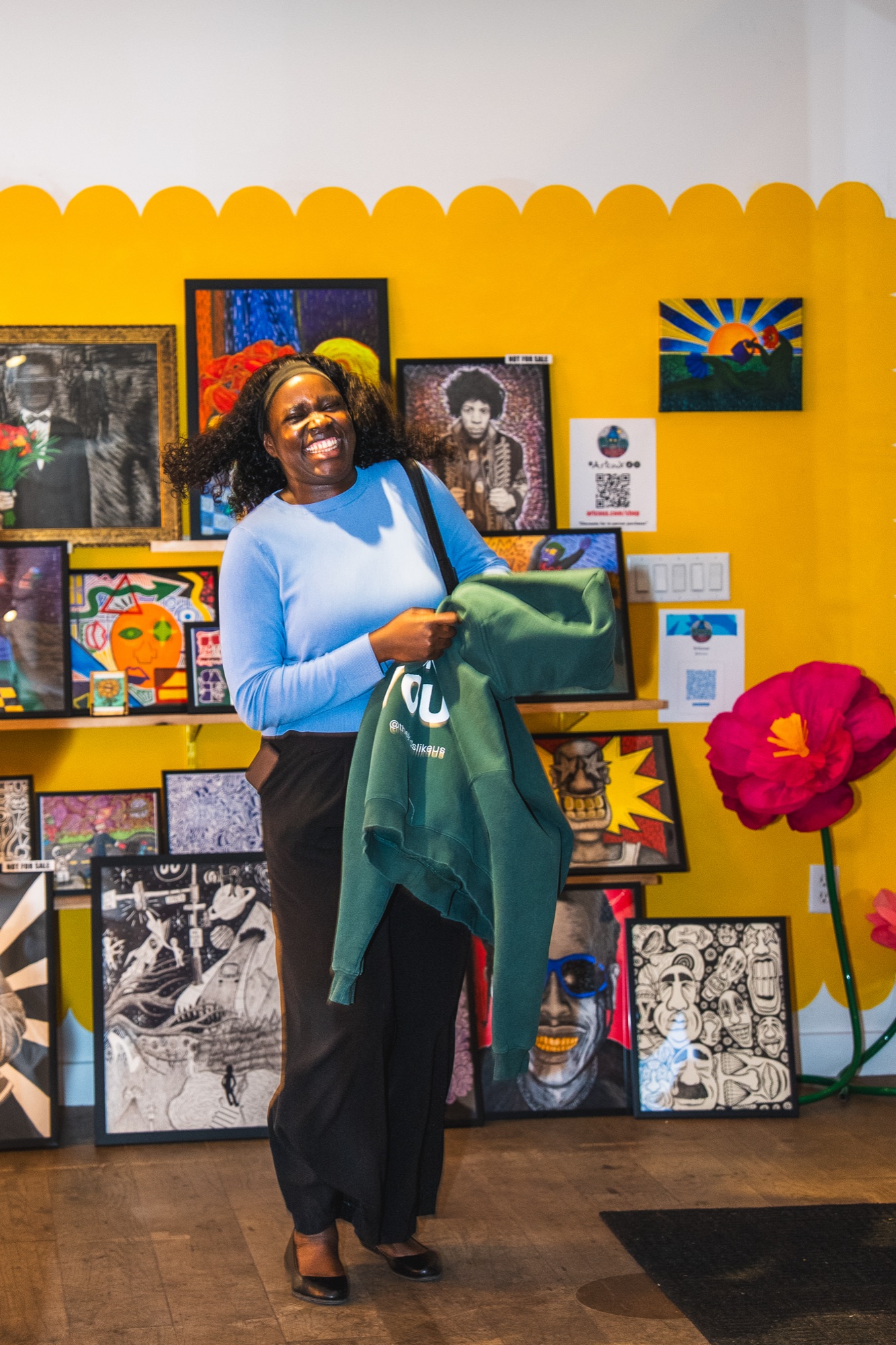 Trying on the collection against the yellow wall at the pop-up