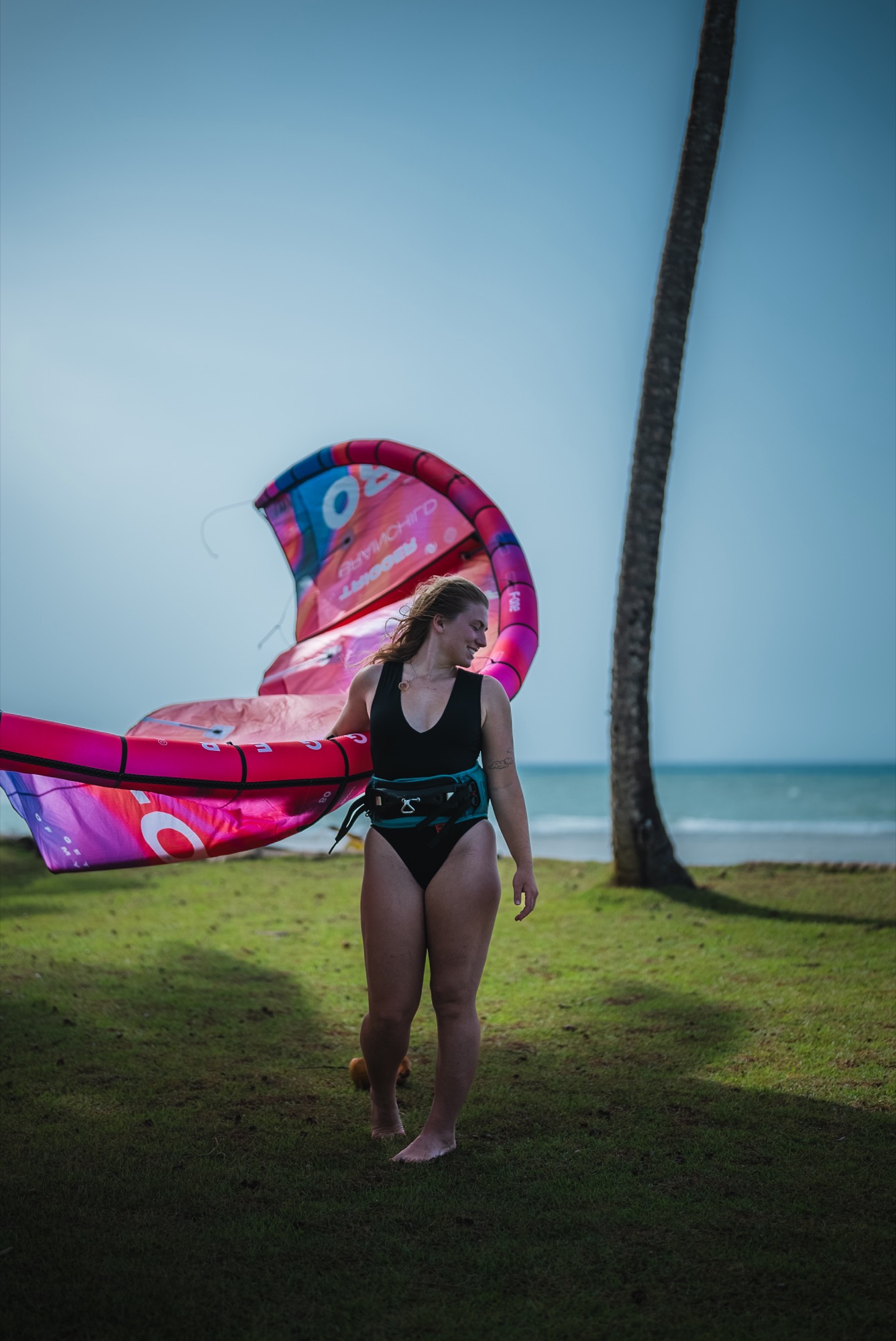 Syd Meyer walking her pink kite across the grass